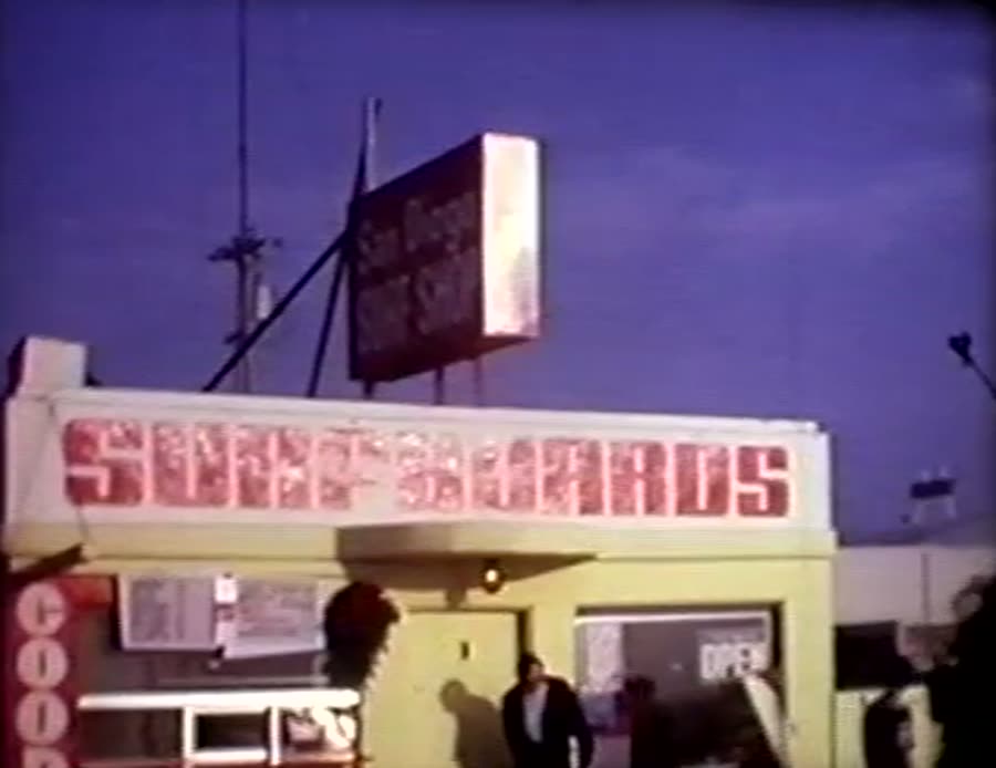 A yellow surf shop with red Surfboards lettering under a San Diego Surf Shop sign